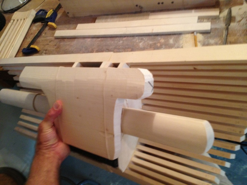 Carved wooden body component held against a tine array, build process