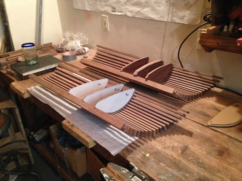 Workshop bench with two walnut tine arrays and paper body templates