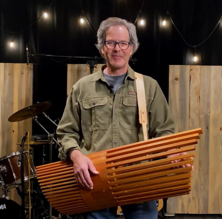 Carl Mueller holding his instrument on the beach